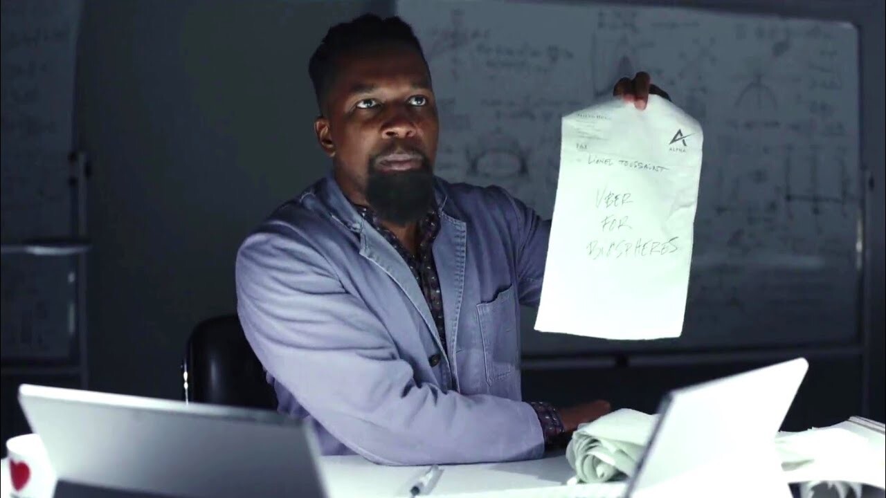 A screenshot from the film Glass Onion, showing Leslie Odom Jr's character holding up a fax printout with his boss's latest stream-of-consciousness idea to innovate with. The paper reads 